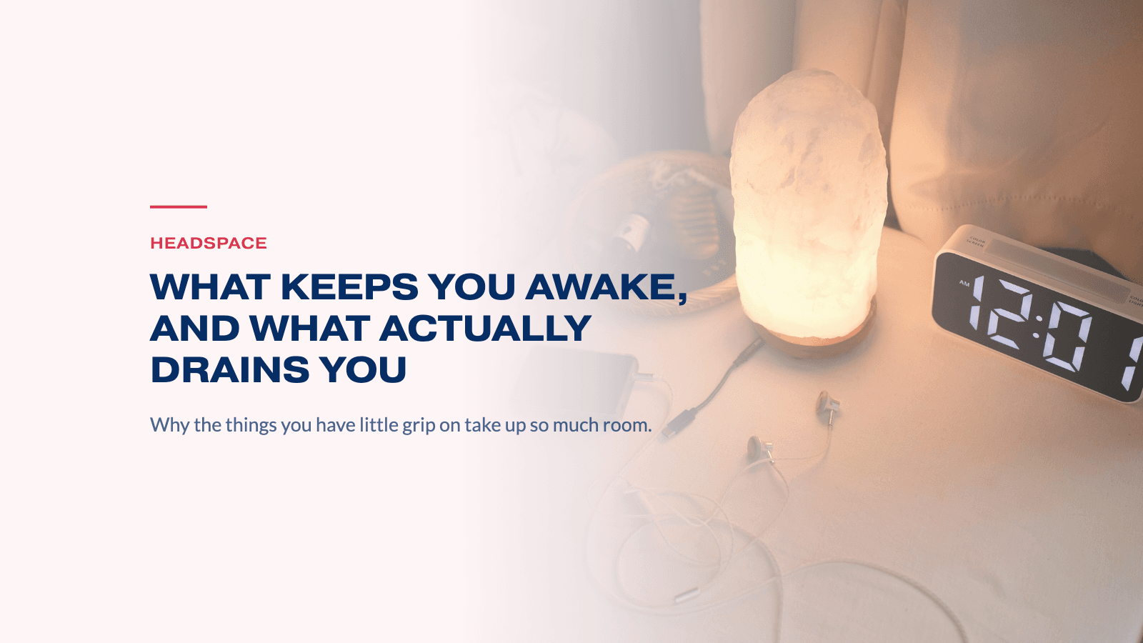 A nightstand at night with a glowing salt lamp and an alarm clock showing 12:01